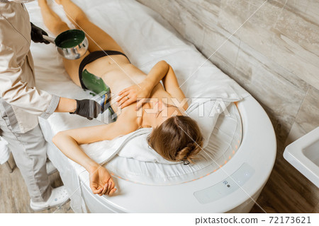 Woman during mud treatment at spa Woman during mud treatment at spa 72173621