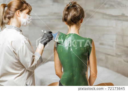 Woman during mud treatment at spa Woman during mud treatment at spa 72173645