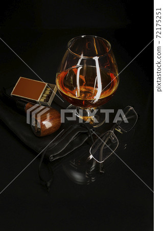 Glass of cognac and smoking pipe 72175251