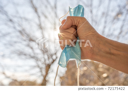 Close up of hand and surgical mask, beating epidemic. Close up of hand and surgical mask, beating epidemic. 72175422