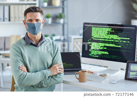 Businessman in mask at IT office 72177146
