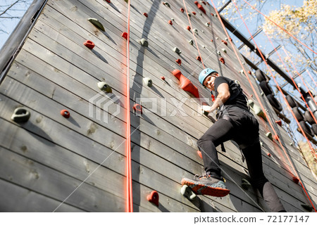 Man climbing the wall in the park 72177147