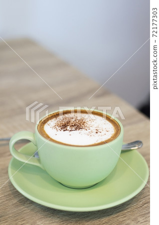 Green Cup Of Coffee Latte On Wooden Background, Close Up Of Art Coffee In Morning. Green Cup Of Coffee Latte On Wooden Background, Close Up Of Art Coffee In Morning. 72177303