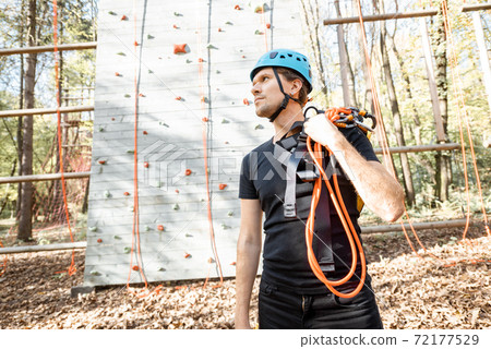 Well equipped man near the climbing wall outdoors 72177529