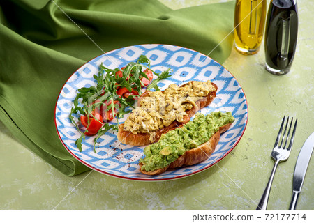 Croissant, egg, avocado, arugula, cherry, truffle. Breakfast food concept. Croissant, egg, avocado, arugula, cherry, truffle. Breakfast food concept. 72177714