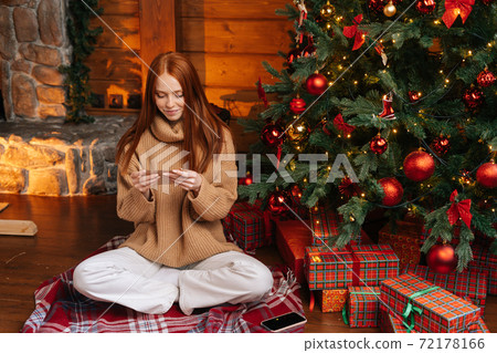 Portrait of happy woman getting Christmas greeting card from her beloved on background of xmas tree. Portrait of happy woman getting Christmas greeting card from her beloved on background of xmas tree. 72178166
