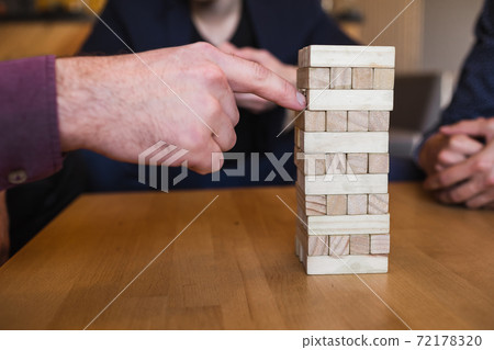 Guys play board game in a stylish loft cafe with a modern design Guys play board game in a stylish loft cafe with a modern design 72178320