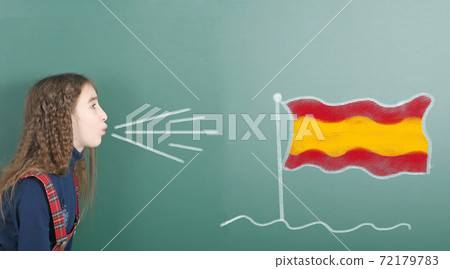 Pre-adolescent girl blowing on Spain flag 72179783