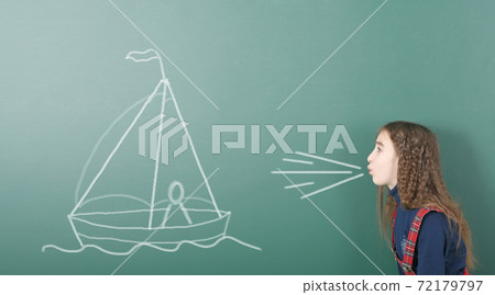 Pre-adolescent girl blowing on painted sailing ship Pre-adolescent girl blowing on painted sailing ship 72179797