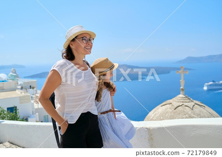 Mother and daughter child walking together on famous tourist island of Santorini Mother and daughter child walking together on famous tourist island of Santorini 72179849