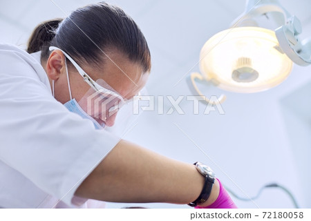 Experienced dentist treats teeth in patient, care and dental health 72180058