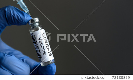 COVID-19 vaccine bottle and syringe for coronavirus cure in doctor`s hand for background 72180859