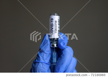 COVID-19 vaccine bottle and syringe for coronavirus cure in doctor`s gloved hands 72180860