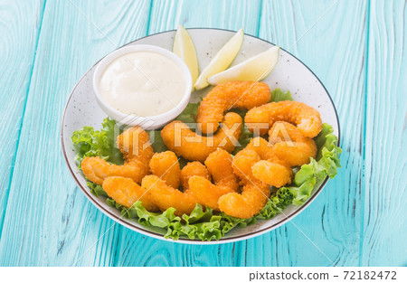 Shrimps in batter with sauce and lime 72182472