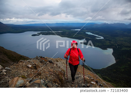 Girl Hiking on top of a Mountain Peak Girl Hiking on top of a Mountain Peak 72183400