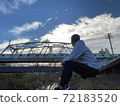 A man twilight with an iron bridge in the background 72183520