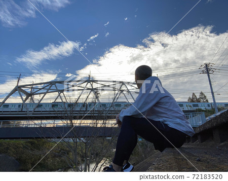 A man twilight with an iron bridge in the background 72183520