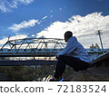A man twilight with an iron bridge in the background 72183524