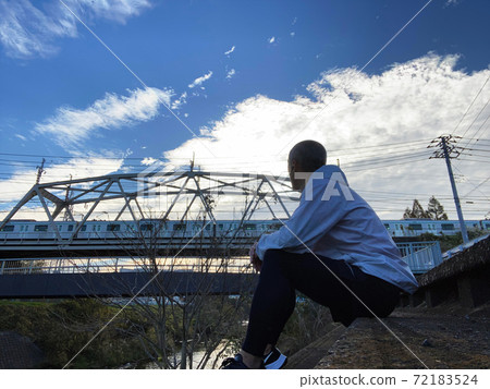 A man twilight with an iron bridge in the background 72183524