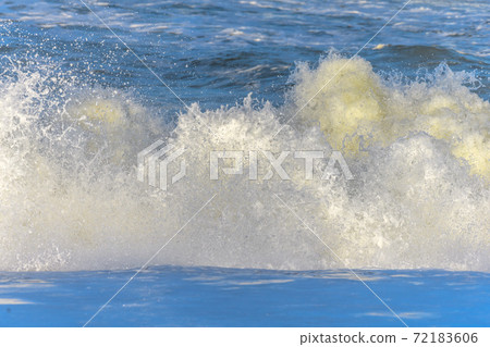 Waves breaking on the beach at the edge of the Atlantic Ocean. 72183606