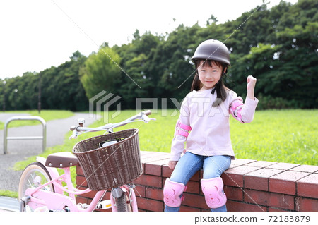 A girl who works hard to practice by taking training wheels on a bicycle 72183879