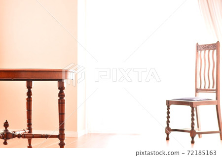 Walnut table on bright windows / chair on background. British antique furniture (clear background, soft focus) Walnut table on bright windows / chair on background. British antique furniture (clear background, soft focus) 72185163
