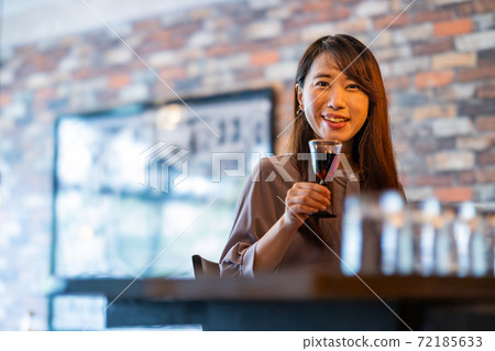 A woman relaxing at the bar 72185633
