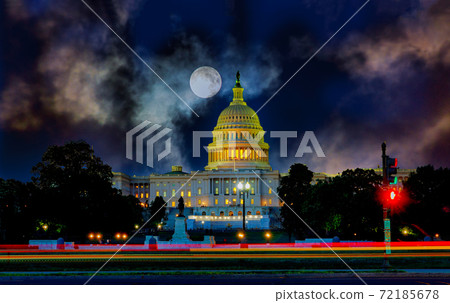 The United States Capitol building with the dome lit up at moon in the dark sky 72185678