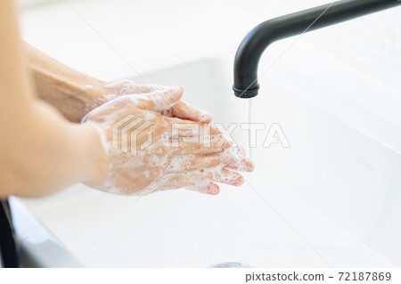 Woman washing hands in the bathroom 72187869