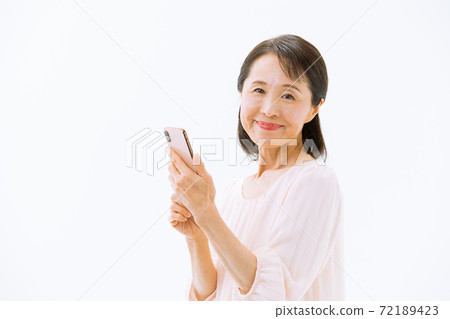 Senior woman with a smartphone smiles Senior woman with a smartphone smiles 72189423