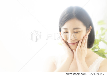 美女形像一個女人將手放在臉頰上，閉上眼睛，微笑 72189447