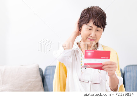 A woman who is worried about looking at her passbook 72189834