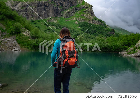 Traveler look at the mountain lake. Travel and active life concept. Traveler look at the mountain lake. Travel and active life concept. 72192550