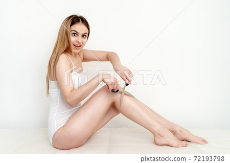 Woman holding scissors near her legs. 72193798