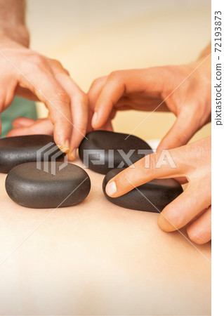 Spa stones on female back 72193873