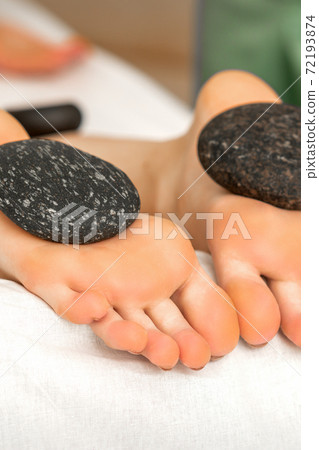 Massage stones on soles feet Massage stones on soles feet 72193874