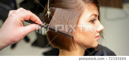 Hairdresser brushing straight female hair 72193889