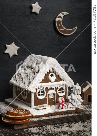 Traditional baking. Gingerbread house and gingerbread stars,. Vertical frame Traditional baking. Gingerbread house and gingerbread stars,. Vertical frame 72197785