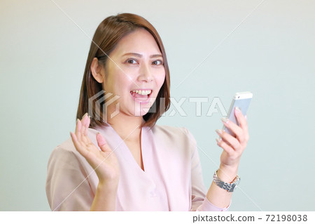 一個有智能手機和驚訝的表情的女人 72198038
