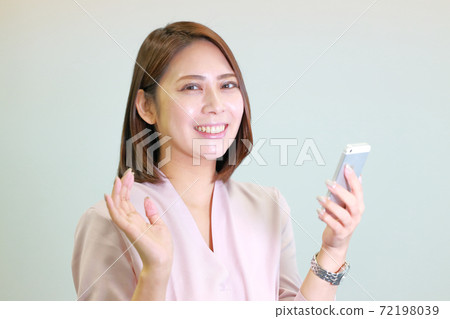 一個女人拿著智能手機,看起來像個atter子 一個女人拿著智能手機,看起來像個atter子 72198039