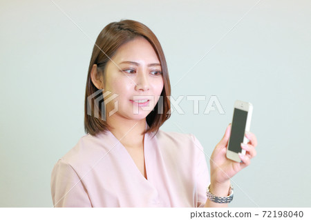 一個女人試圖展示她的智能手機 72198040