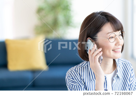 談話在智能手機上的年輕女子 談話在智能手機上的年輕女子 72198067