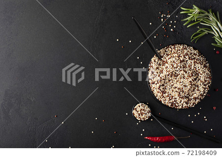 white and red quinoa grits with spices in a black bowl, top view white and red quinoa grits with spices in a black bowl, top view 72198409