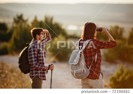 Portrait of happy young couple having fun on their hiking trip. Caucasian and asian hiker couple enjoying themselves on summer vacation. 72198882