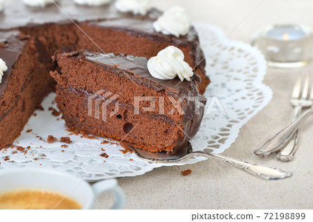 Delicious Viennese cocoa cake with red currant jam and covered with fine dark chocolate and cream Delicious Viennese cocoa cake with red currant jam and covered with fine dark chocolate and cream 72198899