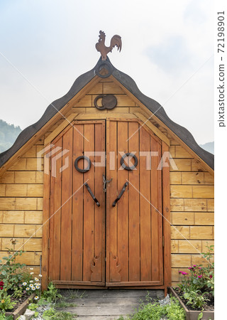 Wooden pantry with doors and roof ridge decorated with a figure of a rooster Wooden pantry with doors and roof ridge decorated with a figure of a rooster 72198901