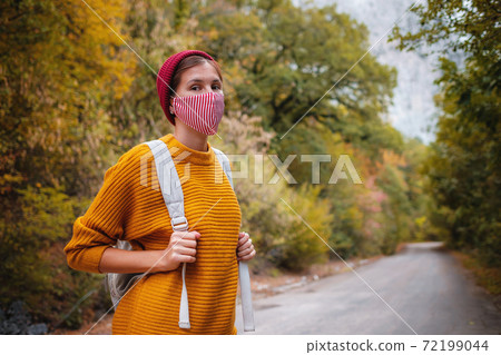 Outdoor fashion photo of young beautiful lady surrounded autumn forest in mountains 72199044