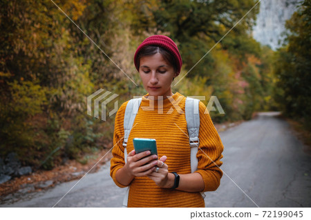 Outdoor fashion photo of young beautiful lady surrounded autumn forest in mountains 72199045