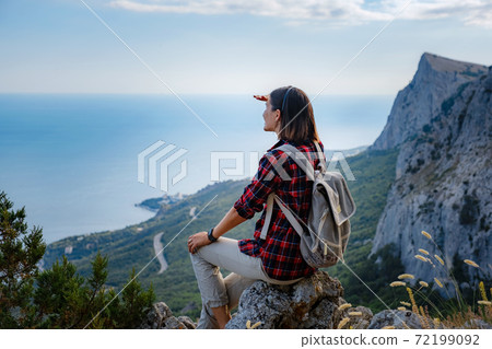 woman hiker enjoy the view at sunset mountain peak cliff woman hiker enjoy the view at sunset mountain peak cliff 72199092