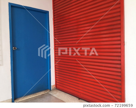 Two doors next to each other, small blue wooden door and big red metal door. Two doors next to each other, small blue wooden door and big red metal door. 72199659